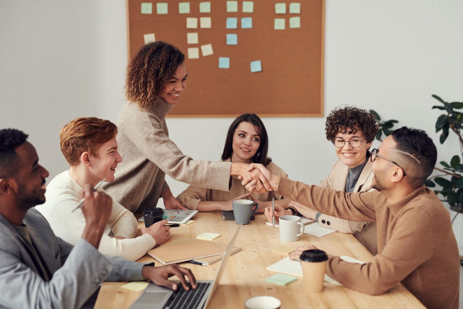 Équipe diverse réunie autour d’un projet numérique dans un bureau lumineux